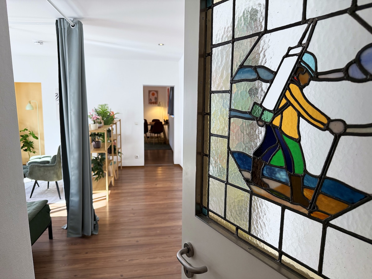 The stained-glass skier in the flat's front door, the living room behind it