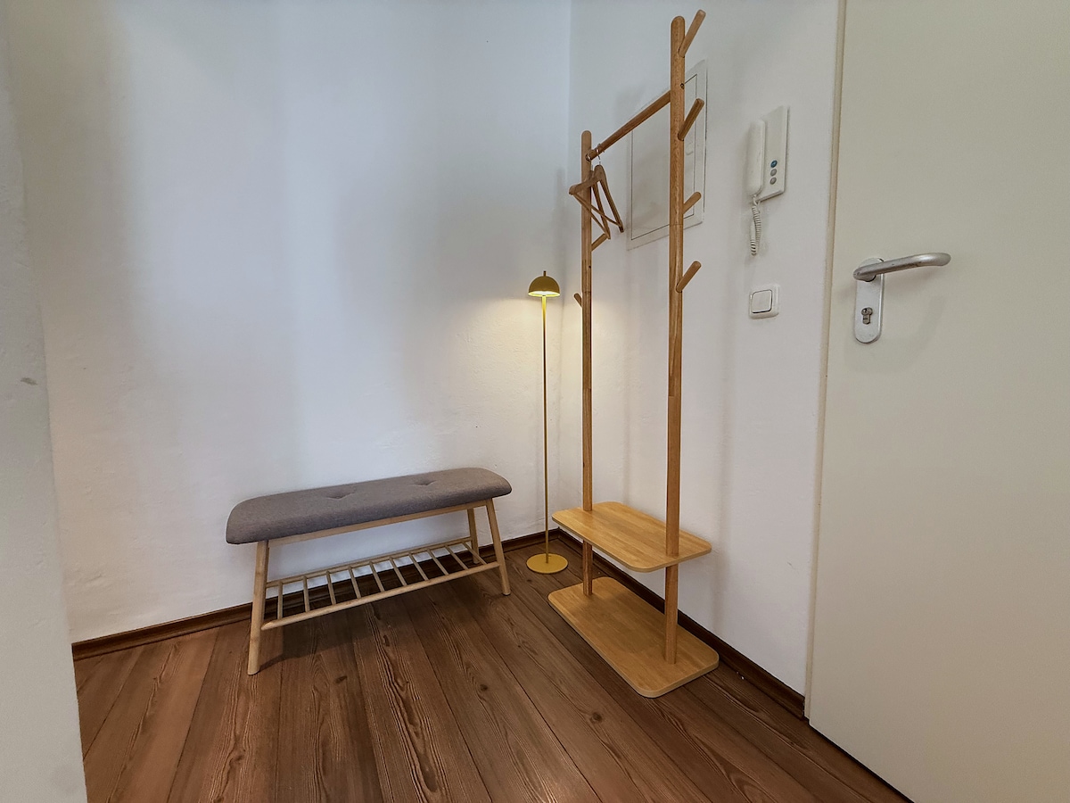 Entrance hall with the bench, the coat stand and the intercom